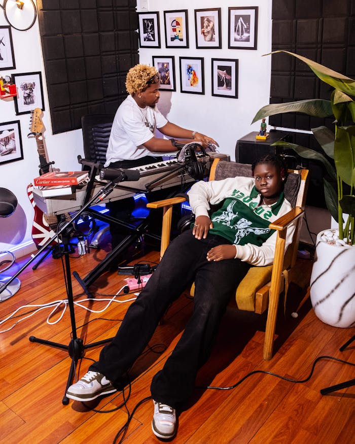 Two musicians in a home studio setting, surrounded by instruments and decor.